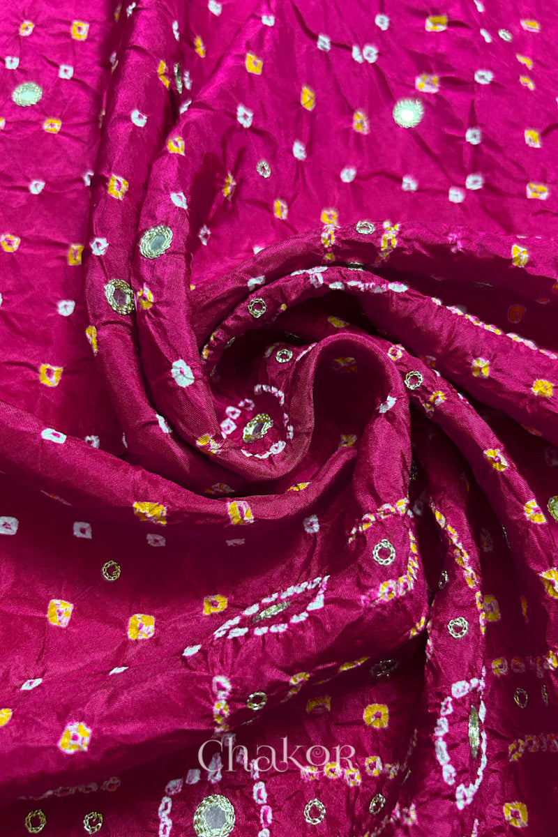 Rani Pink mulberry silk Bandhani (Rai Bandhej) fabric with white and yellow tie-dyed motifs, golden zari mirror and sequin embellishment, arranged in a swirling design – CHAKOR.