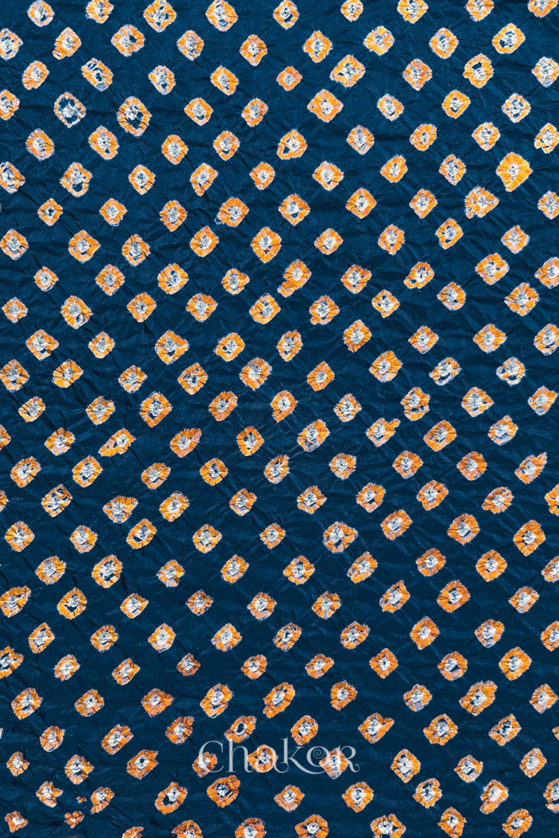 Deep Indigo Mulberry silk fabric showcasing dual colour Yellow bandhani patterns and Chakor brand watermark.