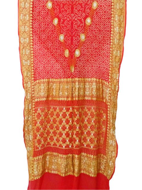Red and gold Bandhani saree drapd against a white background.