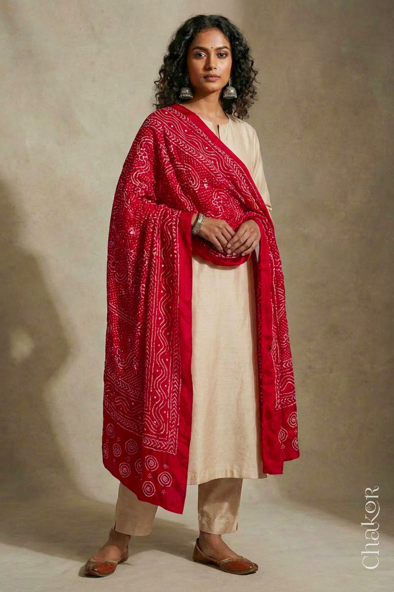 Model wearing red Bandhani mulberry silk dupatta with tie-dye dot pattern draped over a beige kurta.