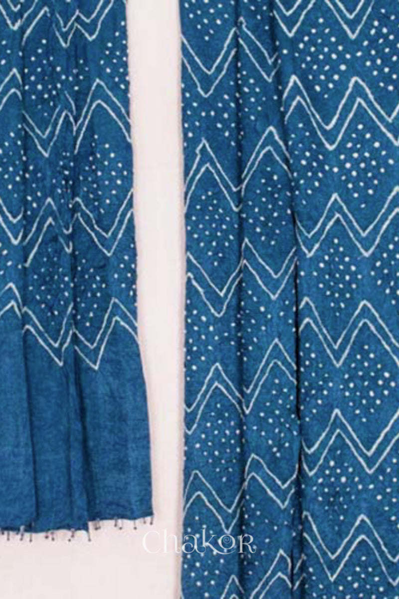 close-up of blue rai bandhej dupatta in gaji silk ,pallu edge detailed with beads.Text reads Chakor brand watermark.
