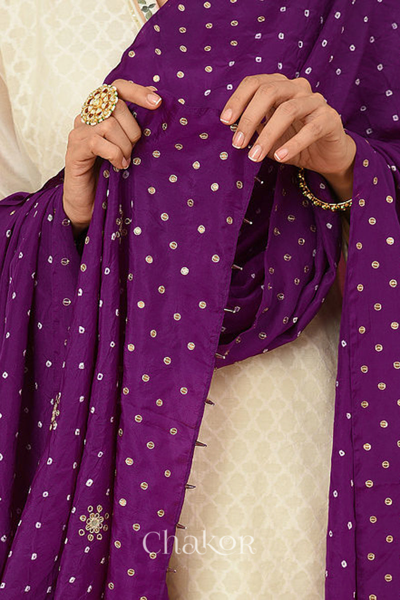Close up of model wearing Wine Bandhani Mulberry Silk Dupatta featuring sequin and zari embroidery with beads pallu edgeover an offwhite kurta.