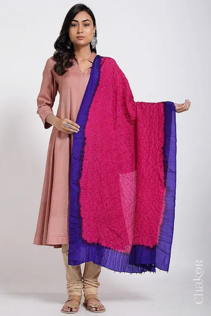 Woman wearing pink & purple border Bandhani mulberry silk dupatta with tie-dye dot pattern & detailed with Bead edging.