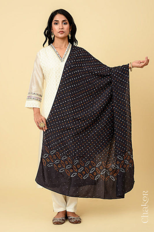 Woman wearing black Bandhani mulberry silk dupatta with multi colour tie-dye dot pattern & detailed with mukaish work &  Bead edging.