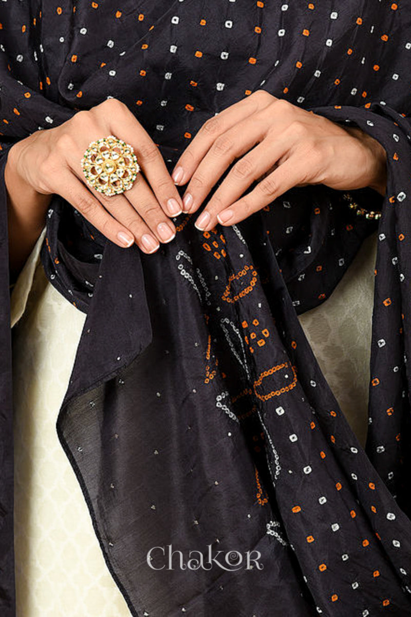 Woman wearing black Bandhani mulberry silk dupatta with multi colour tie-dye dot pattern & detailed with mukaish work &  Bead edging.