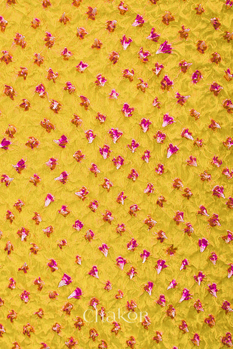 Close up of yellow Bandhani mulberry silk stole with pink tie-dye dot pattern.