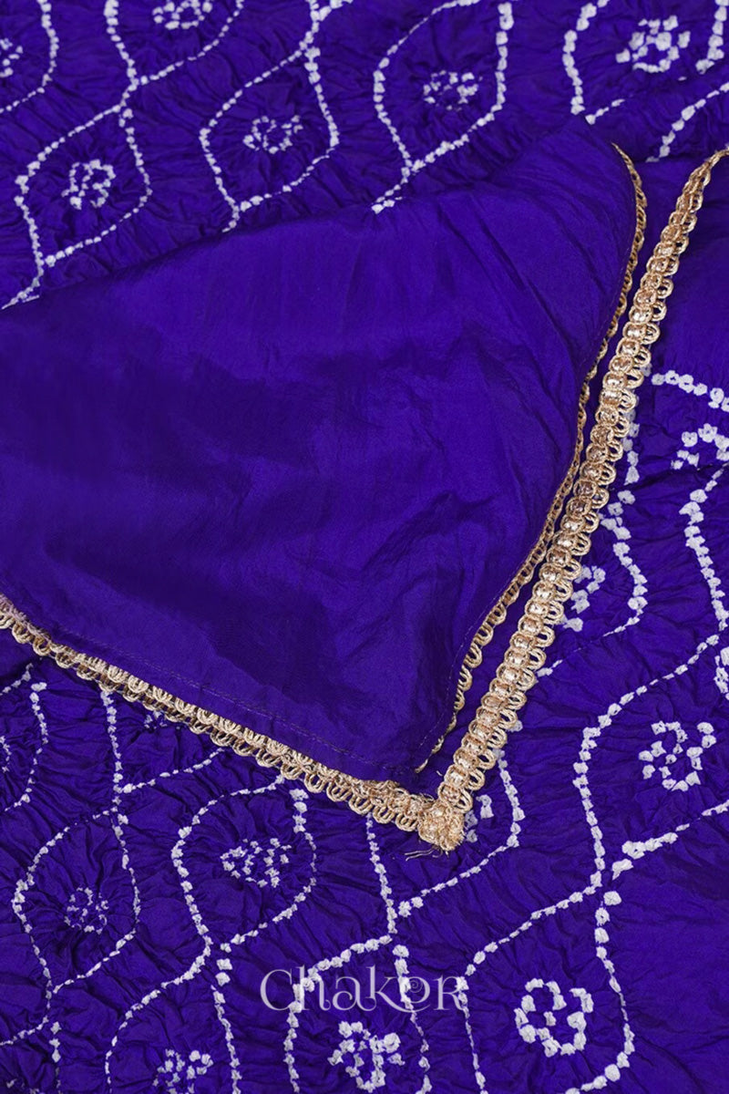 Close up of purple Bandhani mulberry silk dupatta with tie-dye dot pattern & detailed with golden lace.