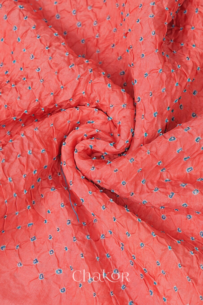 Close up of peach Bandhani mulberry silk dupatta with tie-dye dot pattern & detailed with golden lace.