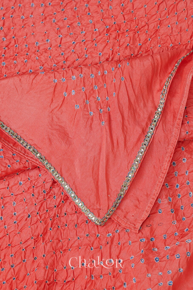 Close up of peach Bandhani mulberry silk dupatta with tie-dye dot pattern & detailed with golden lace.