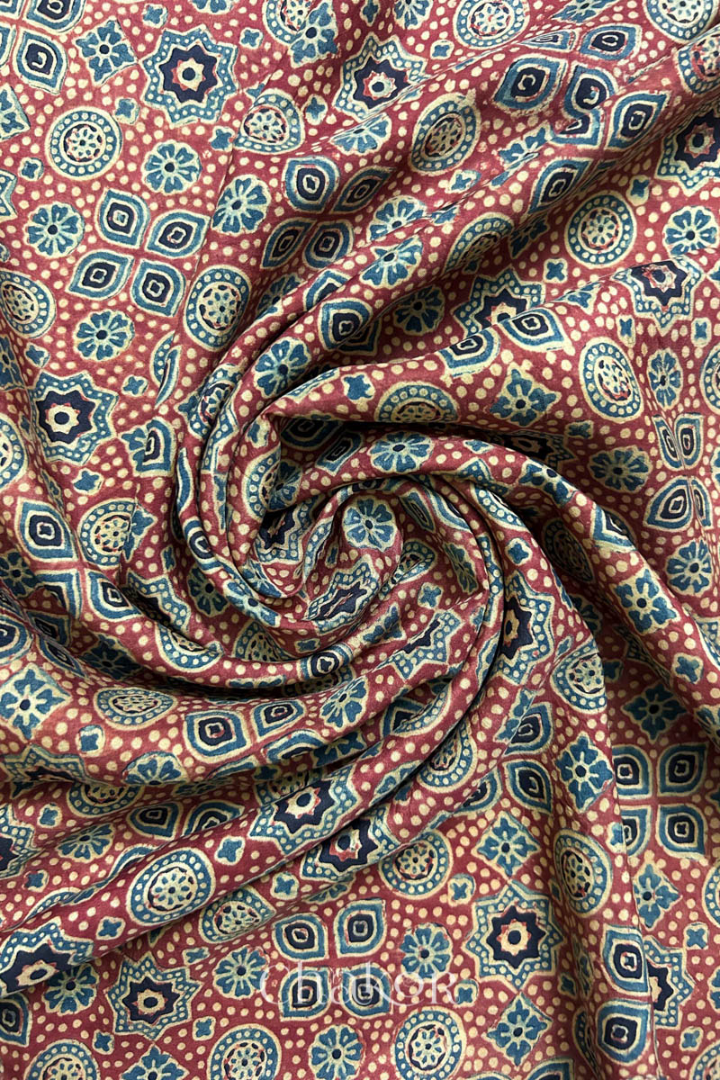 Natural red Ajrakh printed pure Mulberry silk fabric drape with elegant sheen.