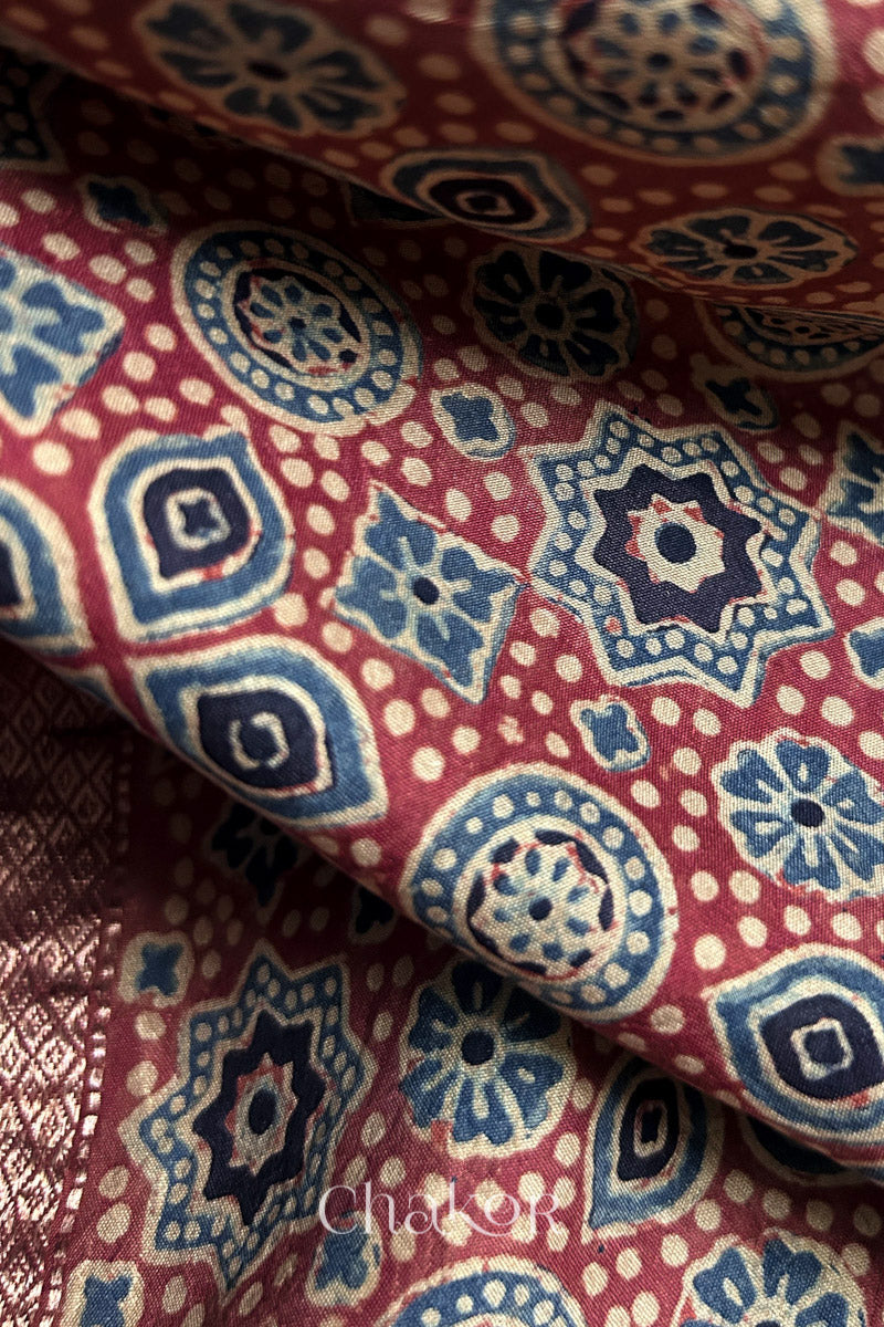 Close-up of traditional Ajrakh hand-block motifs on handloom red silk.