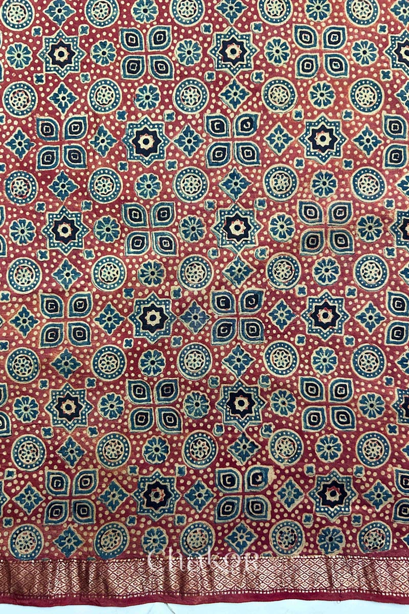 View of hand-block printed red silk blouse fabric with Zari border edges.