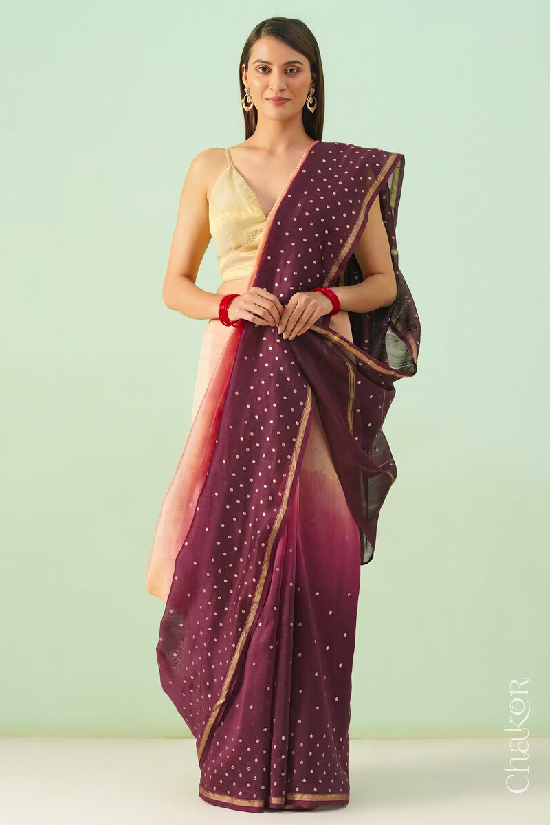Model standing in peach maroon shaded Chanderi silk cotton saree highlighting the handloom drape.
