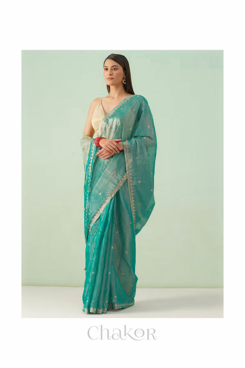 Model wearing peacock blue Chanderi tissue silk cotton saree in a full-length promotional shot.
