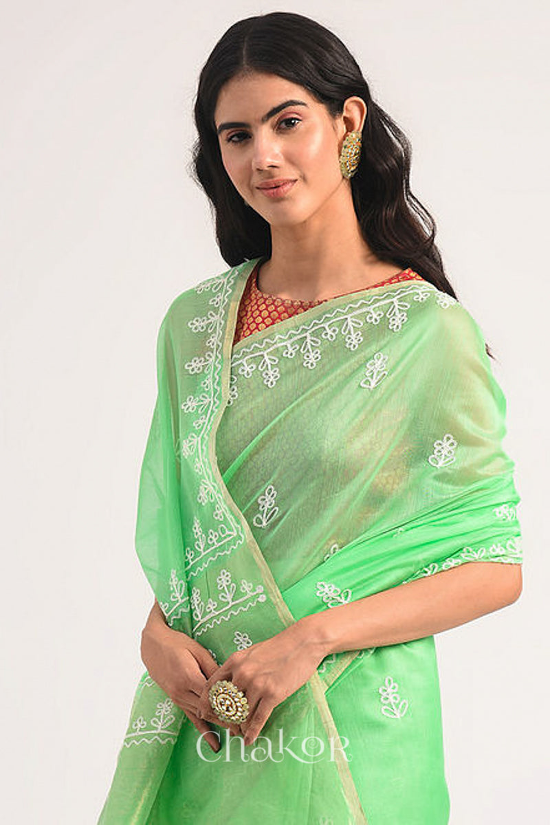 Front close view of sea green Chanderi silk cotton saree highlighting aari embroidery details.
