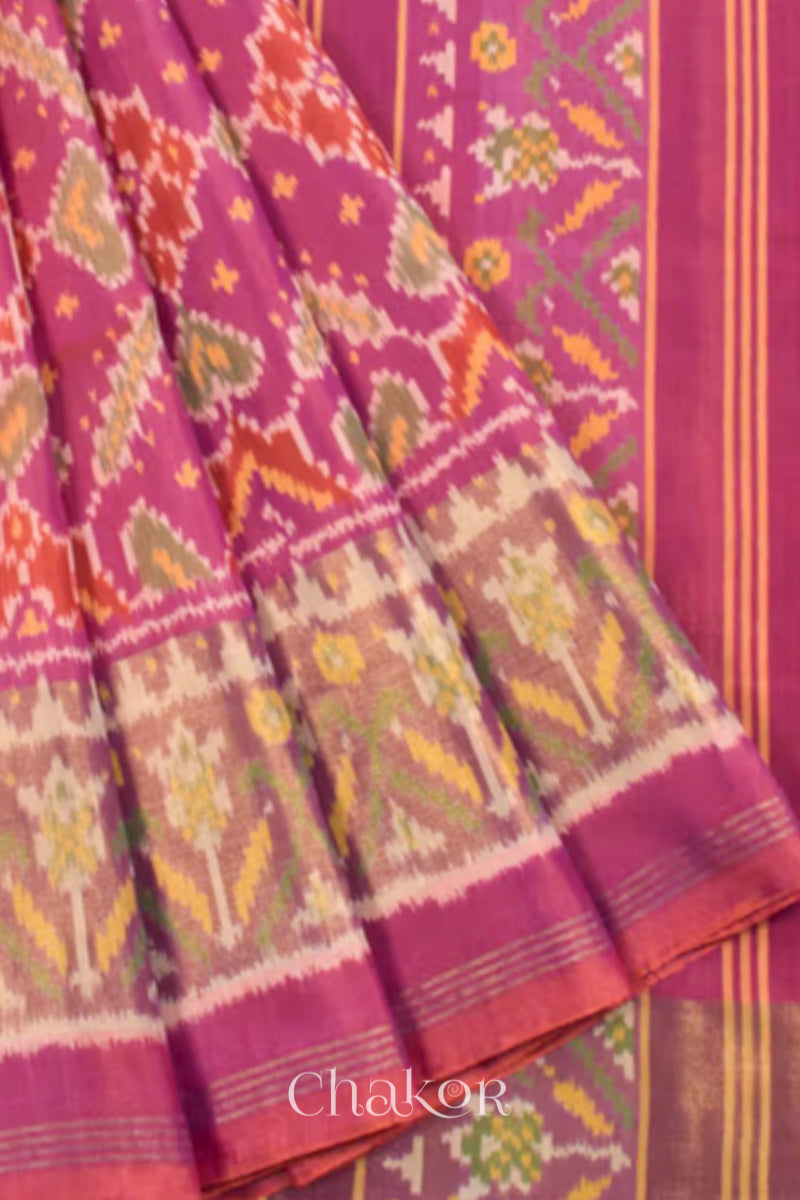 Close up of Handloom Pink Rajkoti Patola Ikat Mulberry Silk Saree with tissue borders, and mauve pallu woven using traditional designs in Gujarat.