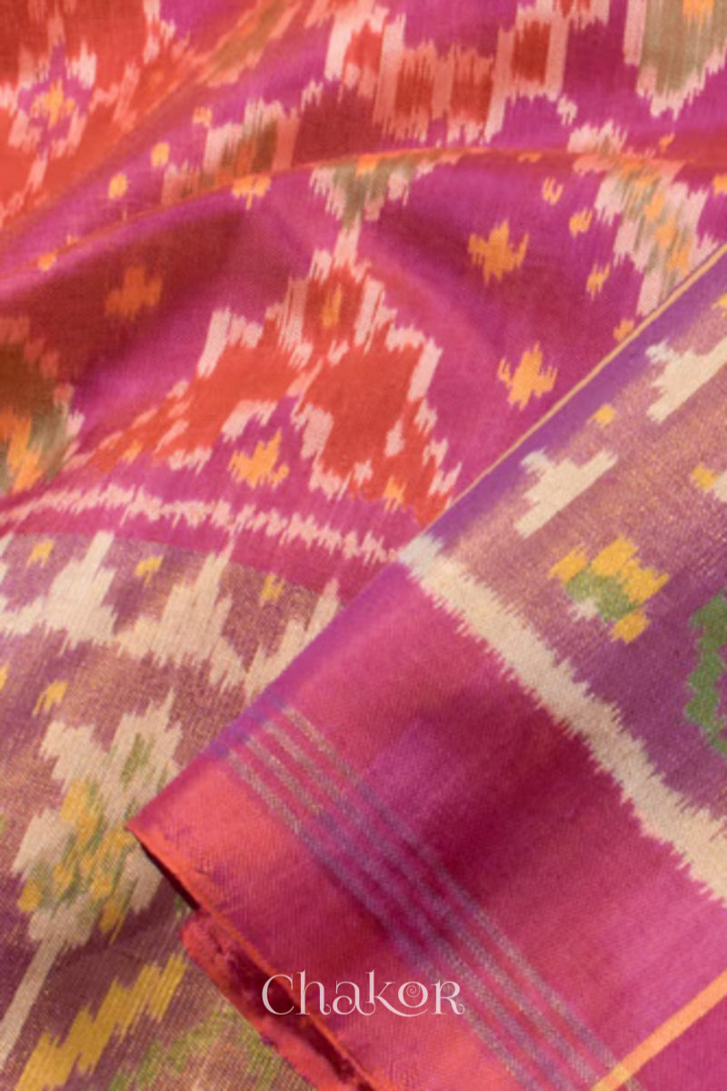 Close up of Handloom Pink Rajkoti Patola Ikat Mulberry Silk Saree with tissue borders, and mauve pallu woven using traditional designs in Gujarat.