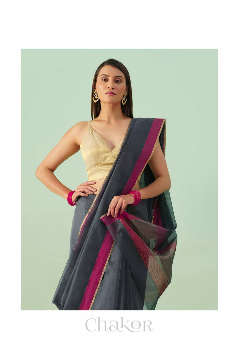 Model wearing a Maroon Chanderi silk cotton saree with tissue pallu and Ganga Jamuna borders, handwoven in Chanderi.
