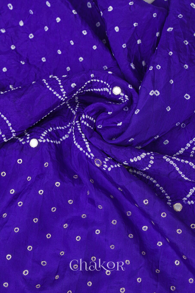Close-up of a purple Bandhani mulberry silk dupatta with tie-dye dot pattern & detailed with mirror work & golden lace on edge