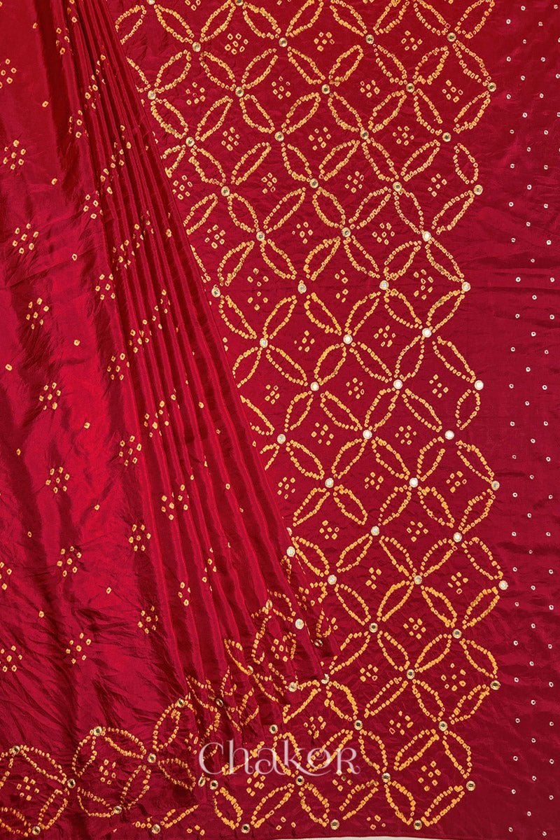 Pleated view of Red Bandhani Mulberry Silk Saree handcrafted with yellow bandhej dots and mirror embroidery.