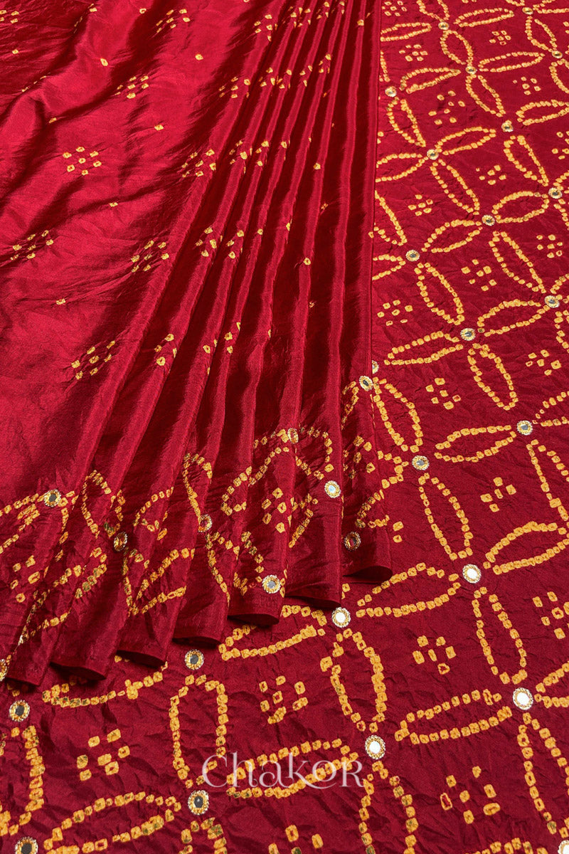 Pleated view of Red Bandhani Mulberry Silk Saree handcrafted with yellow bandhej dots and mirror embroidery.