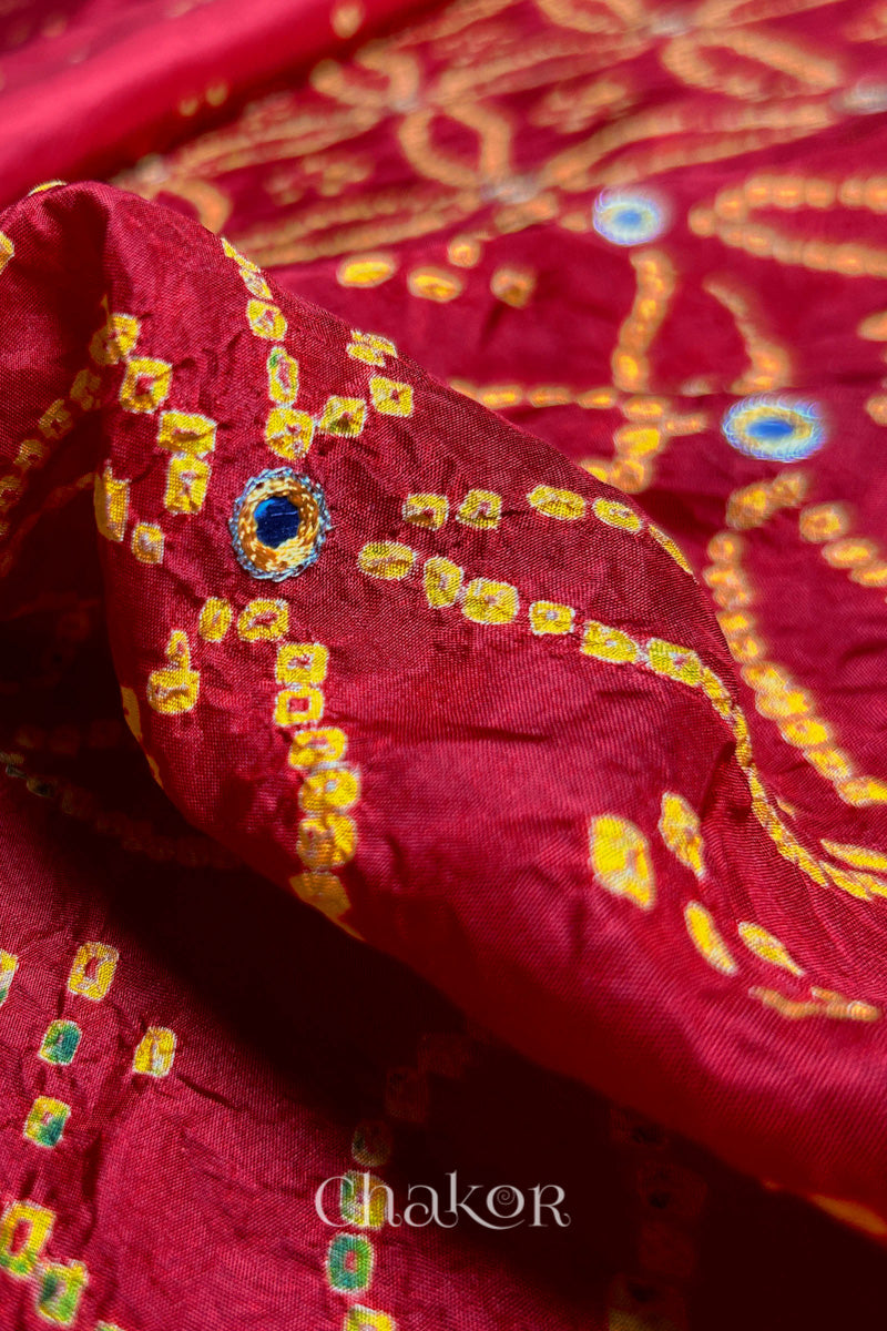 Pleated view of Red Bandhani Mulberry Silk Saree handcrafted with yellow bandhej dots and mirror embroidery.