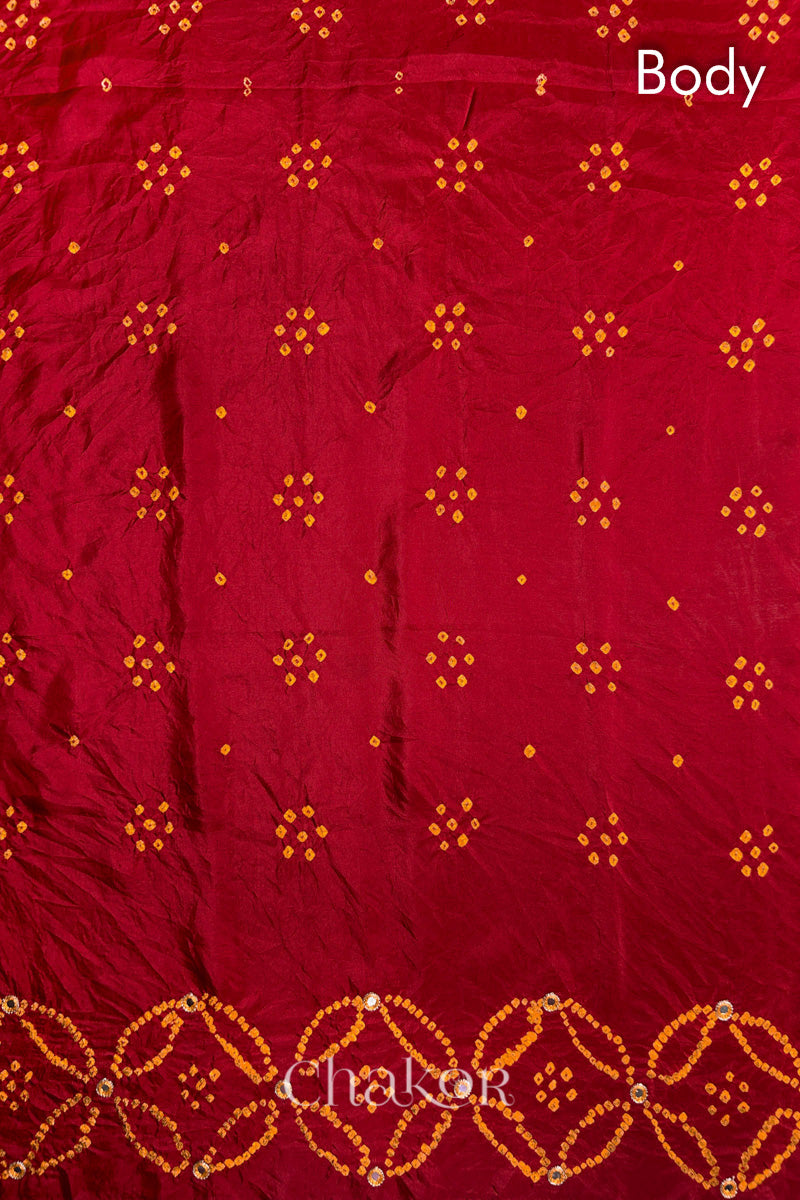 Body pattern of Red Bandhani Mulberry Silk Saree handcrafted with yellow bandhej dots and mirror embroidery.