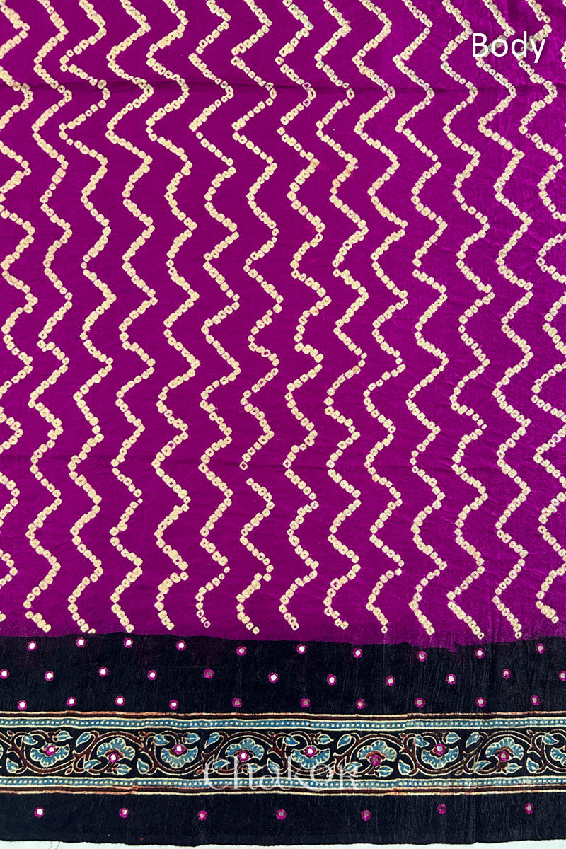 Close up of Magenta Bandhani Saree with Black Ajrakh printed border and pallu in pure gaji silk with traditional bandhej tie-dye & mirror work, handcrafted in Kutch. 