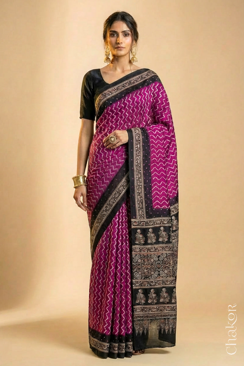 Woman wearing Magenta Bandhani Saree with Black Ajrakh printed border and pallu in pure gaji silk with traditional bandhej tie-dye & mirror work, handcrafted in Kutch. 
