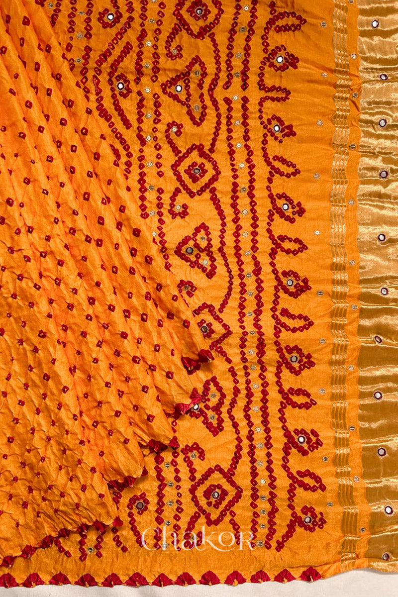 Pleats and pallu view of traditional Yellow Bandhani Gaji Silk Handcrafted Saree, with rai bandhej patterns in red dots and mirror and sequins embroidery.