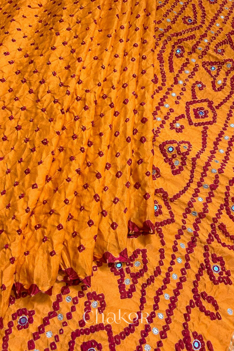 Pleats and pallu view of traditional Yellow Bandhani Gaji Silk Handcrafted Saree, with rai bandhej patterns in red dots and mirror and sequins embroidery.