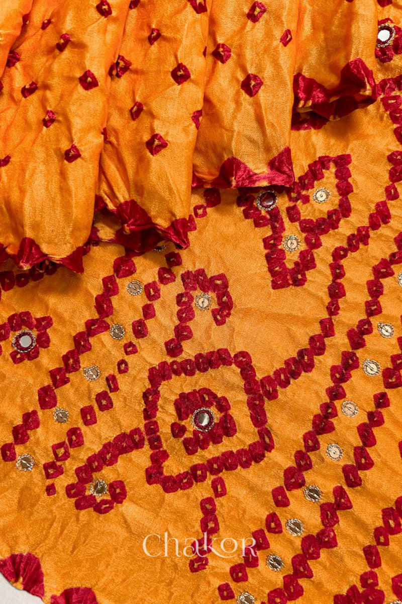 Close up of traditional Yellow Bandhani Gaji Silk Handcrafted Saree, with rai bandhej patterns in red dots and mirror and sequins embroidery.