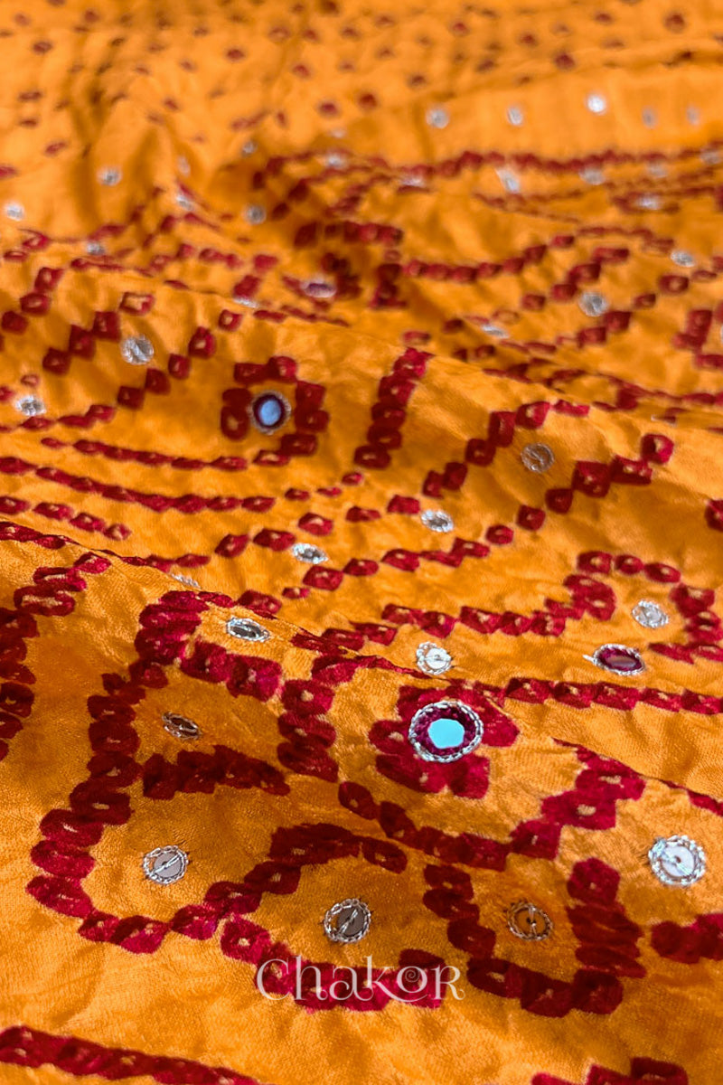 Close up of traditional Yellow Bandhani Gaji Silk Handcrafted Saree, with rai bandhej patterns in red dots and mirror and sequins embroidery.