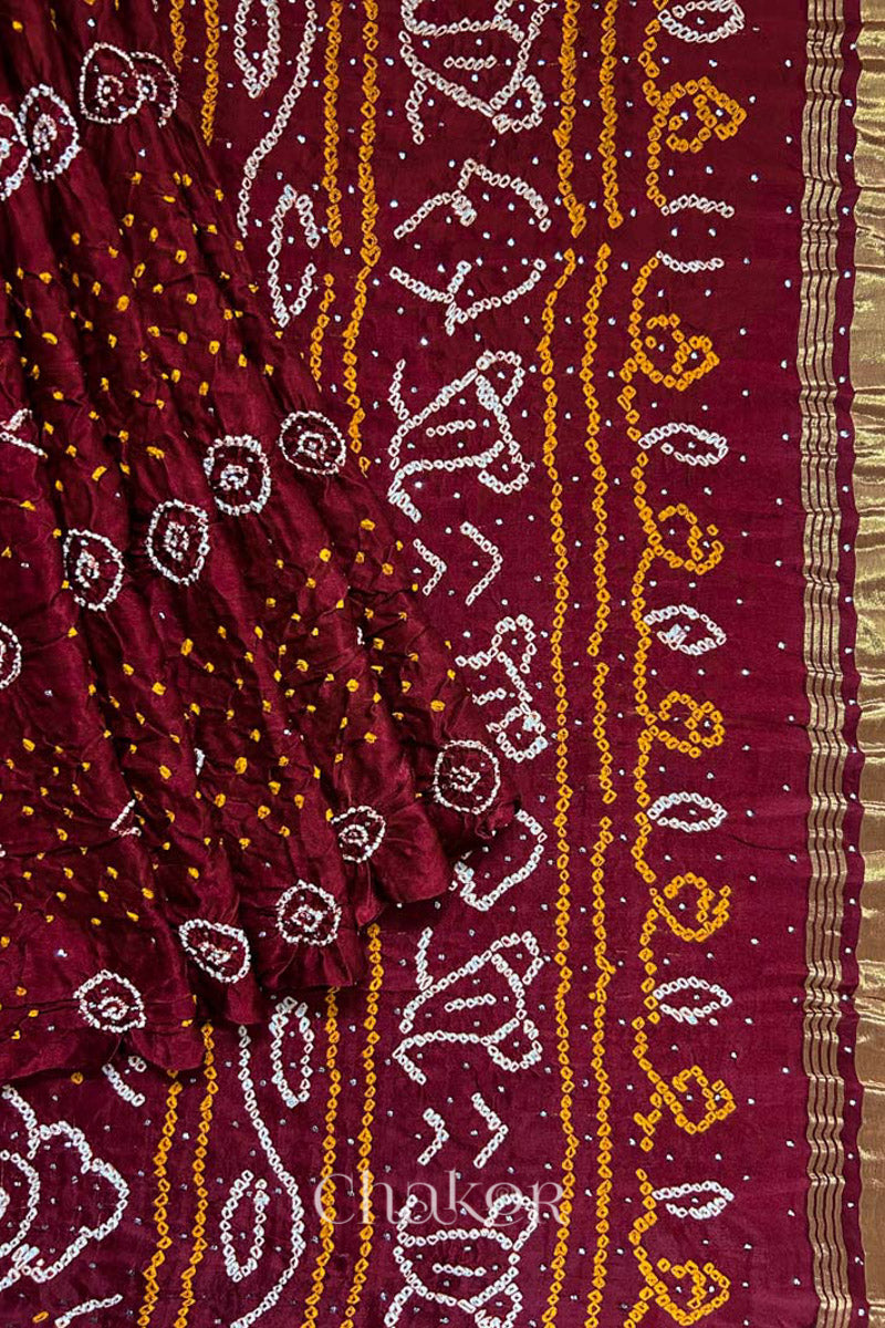 Pleats and pallu view of Handcrafted Maroon Bandhani Gaji Silk Saree with traditional rai bandhej patterns and mukaish embroidery.