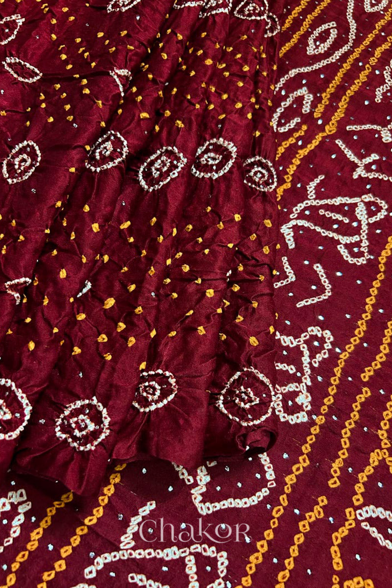 Pleats and pallu view of Handcrafted Maroon Bandhani Gaji Silk Saree with traditional rai bandhej patterns and mukaish embroidery.