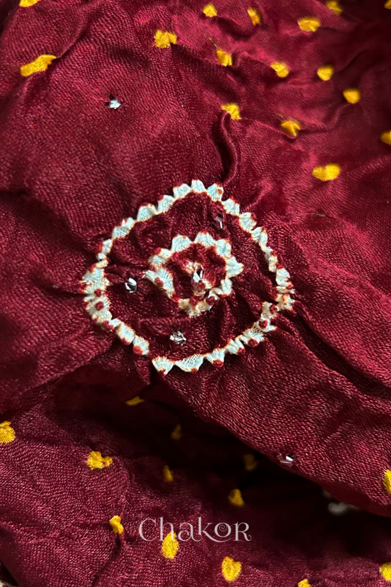 Close up of Handcrafted Maroon Bandhani Gaji Silk Saree with traditional rai bandhej patterns and mukaish embroidery.
