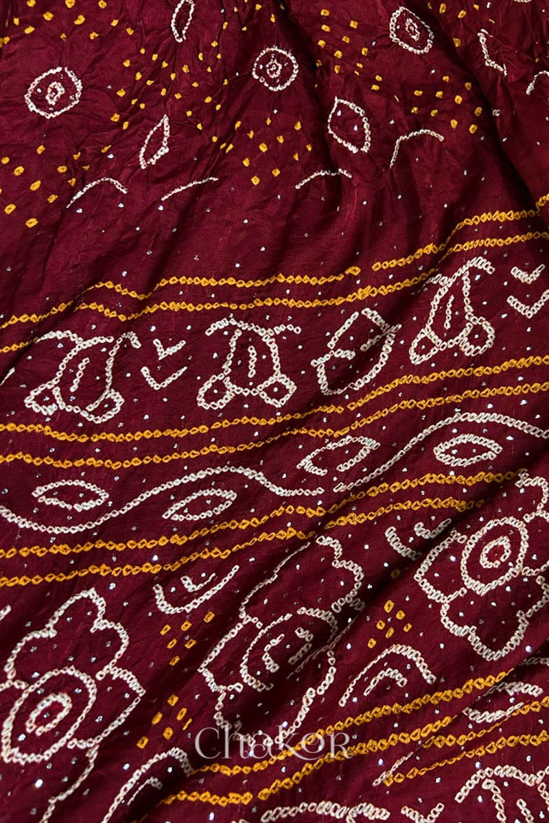 Close up of Handcrafted Maroon Bandhani Gaji Silk Saree with traditional rai bandhej patterns and mukaish embroidery.