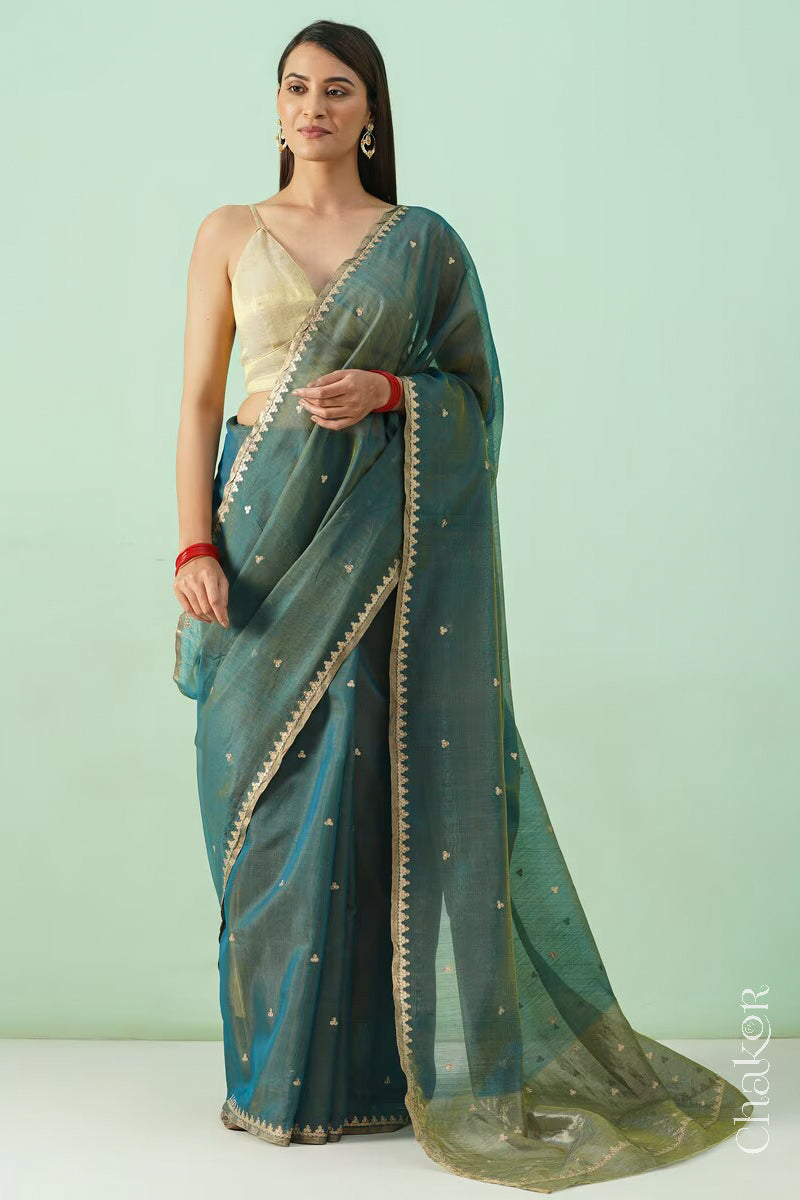 Full view of model dressed in Teal Blue Chanderi  silk cotton saree draped to display sequin tikki embroidery.
