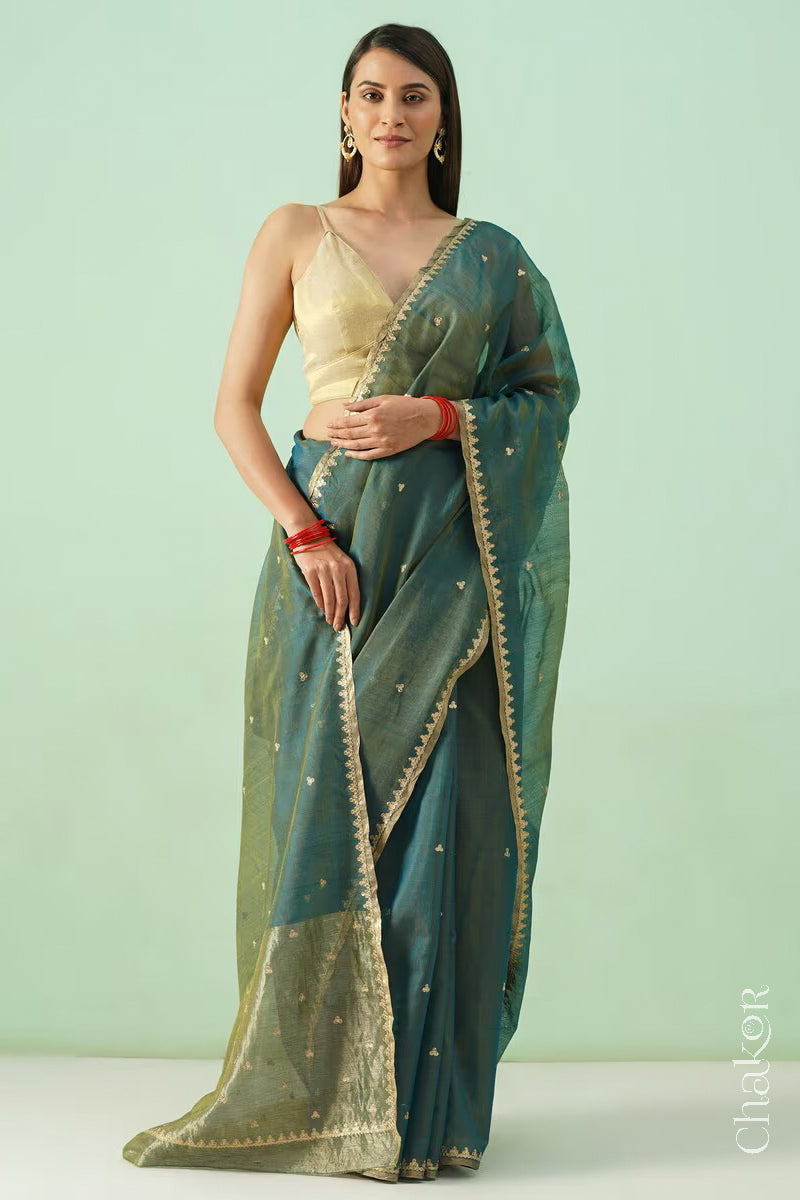 Full view of model dressed in Teal Blue Chanderi  silk cotton saree draped to display sequin tikki embroidery.
