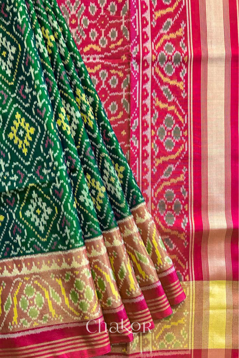 Close up of Handloom Green Rajkoti Patola Ikat Mulberry Silk Saree with red border pallu, woven using traditional designs in Gujarat.