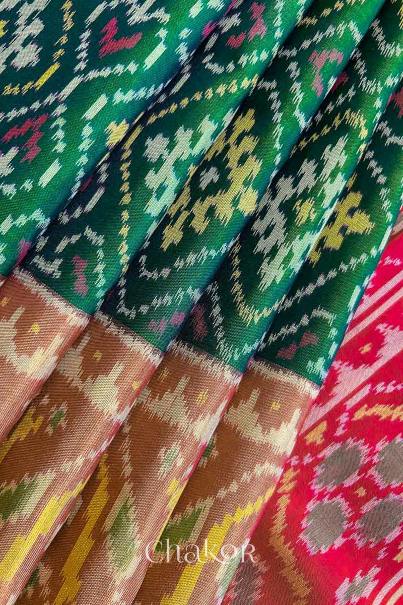Close up of Handloom Green Rajkoti Patola Ikat Mulberry Silk Saree with red border pallu, woven using traditional designs in Gujarat.