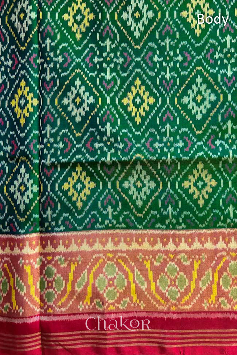 Close up of Handloom Green Rajkoti Patola Ikat Mulberry Silk Saree with red border pallu, woven using traditional designs in Gujarat.