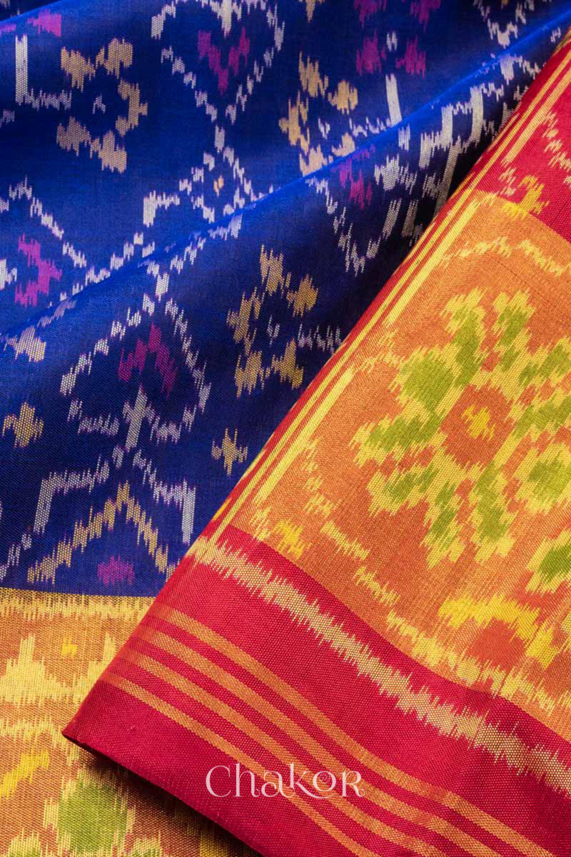 Close up of Handloom Blue and Red Ikat Patola Mulberry Pure Silk Saree, with traditional design handcrafted in Rajkot.