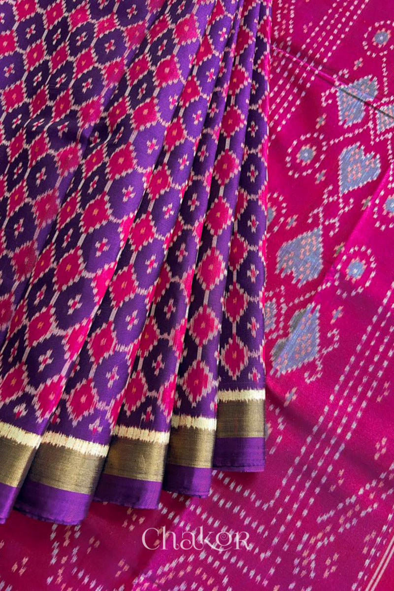 Pleats laid flat on pallu Handloom Purple Pink Patola Ikkat Mulberry Silk Saree in traditional patterns.