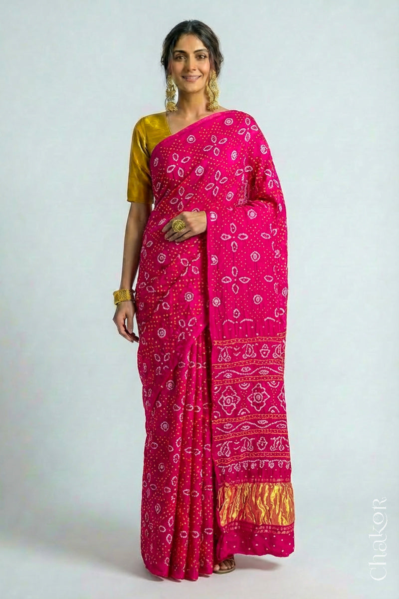 Woman wearing Handcrafted Rani pink Bandhani Gaji Silk Saree with traditional bandhej patterns and sequins embroidery.