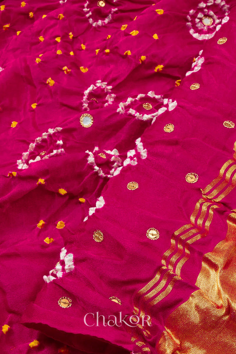 Close up of Handcrafted Rani pink Bandhani Gaji Silk Saree with traditional bandhej patterns and sequins embroidery.