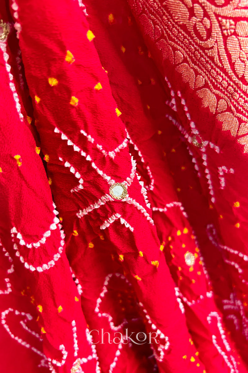 Close up of  Handcrafted Red Bandhani Banarasi Georgette Saree in pure silk featuring zari weaving and Kutch Bandhej with mirror embroidery, Perfect for wedding and occasions.