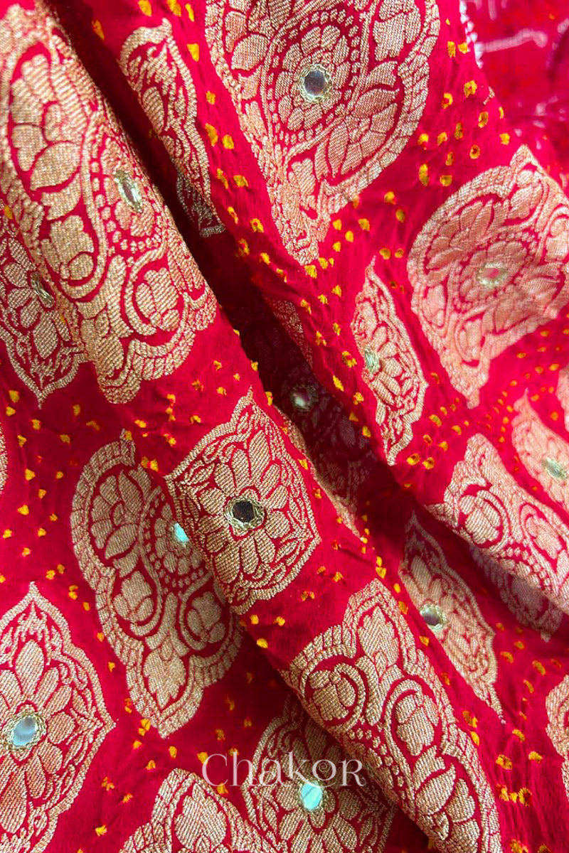 Close up of  Handcrafted Red Bandhani Banarasi Georgette Saree in pure silk featuring zari weaving and Kutch Bandhej with mirror embroidery, Perfect for wedding and occasions.
