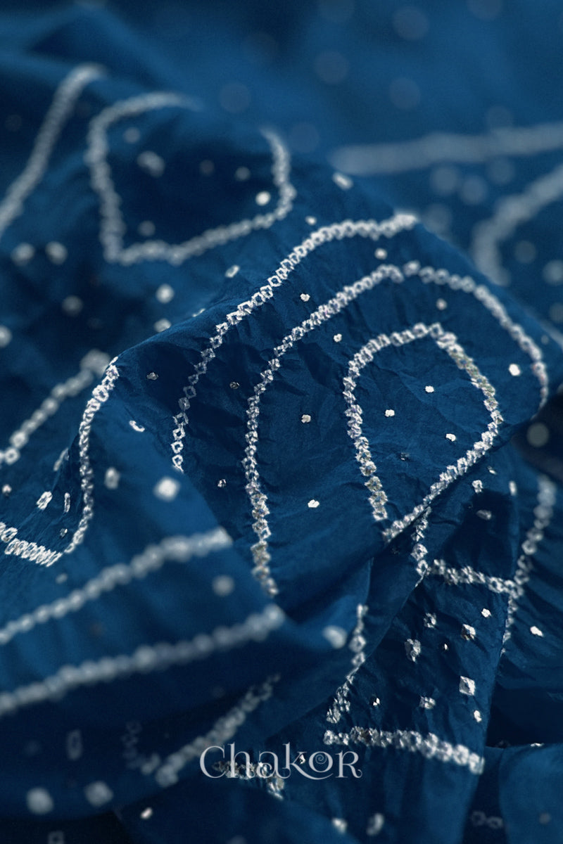 Close up of indigo blue Bandhani Mulberry Silk Saree, handcrafted in rai bandhej patterns with mukaish embroidery.