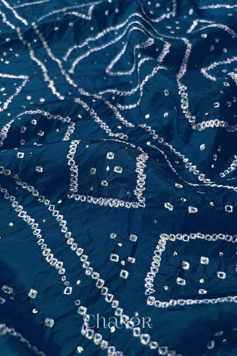 Close up of indigo blue Bandhani Mulberry Silk Saree, handcrafted in rai bandhej patterns with mukaish embroidery.